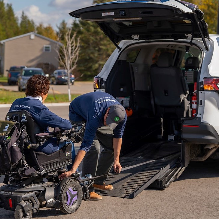 man in wheelchair being loaded onto shuttle