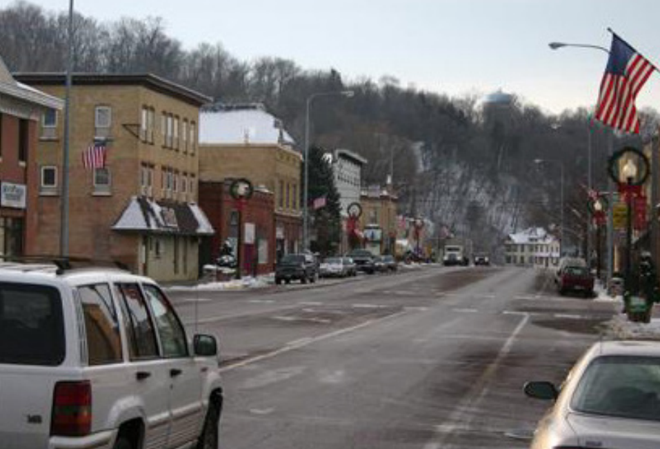 Highway 21 in downtown Jordan before construction, showing a three-lane road with a faded crosswalk at the intersection.